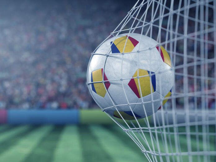 Flag of Romania on the ball in football net. Conceptual 3D rendering