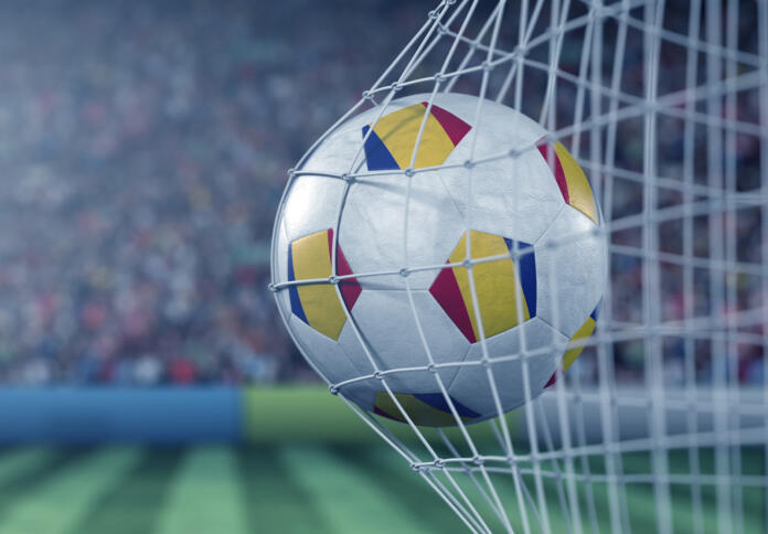 Flag of Romania on the ball in football net. Conceptual 3D rendering
